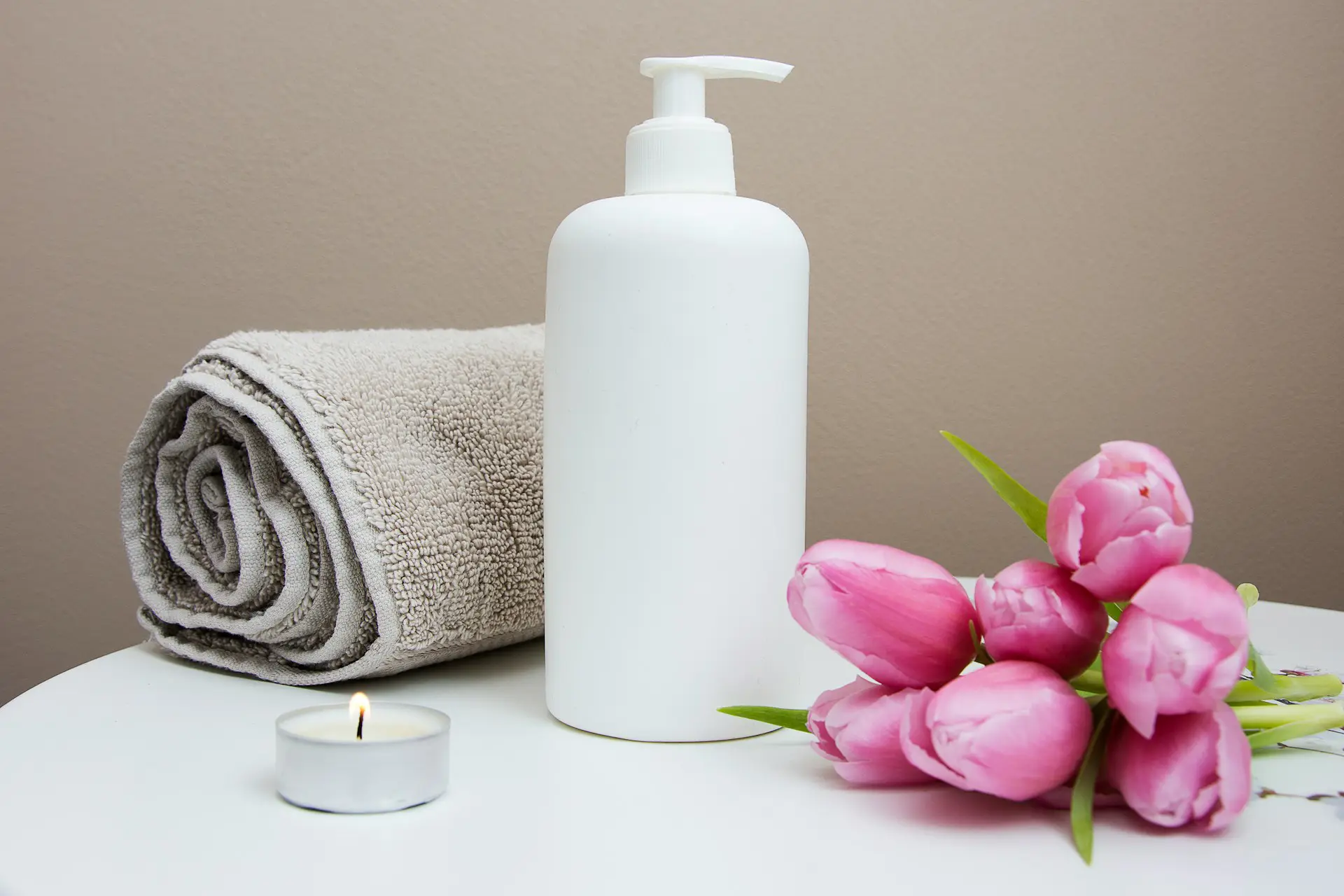 Spa towels, accessories, and bath essentials arranged neatly, surrounded by flowers.
