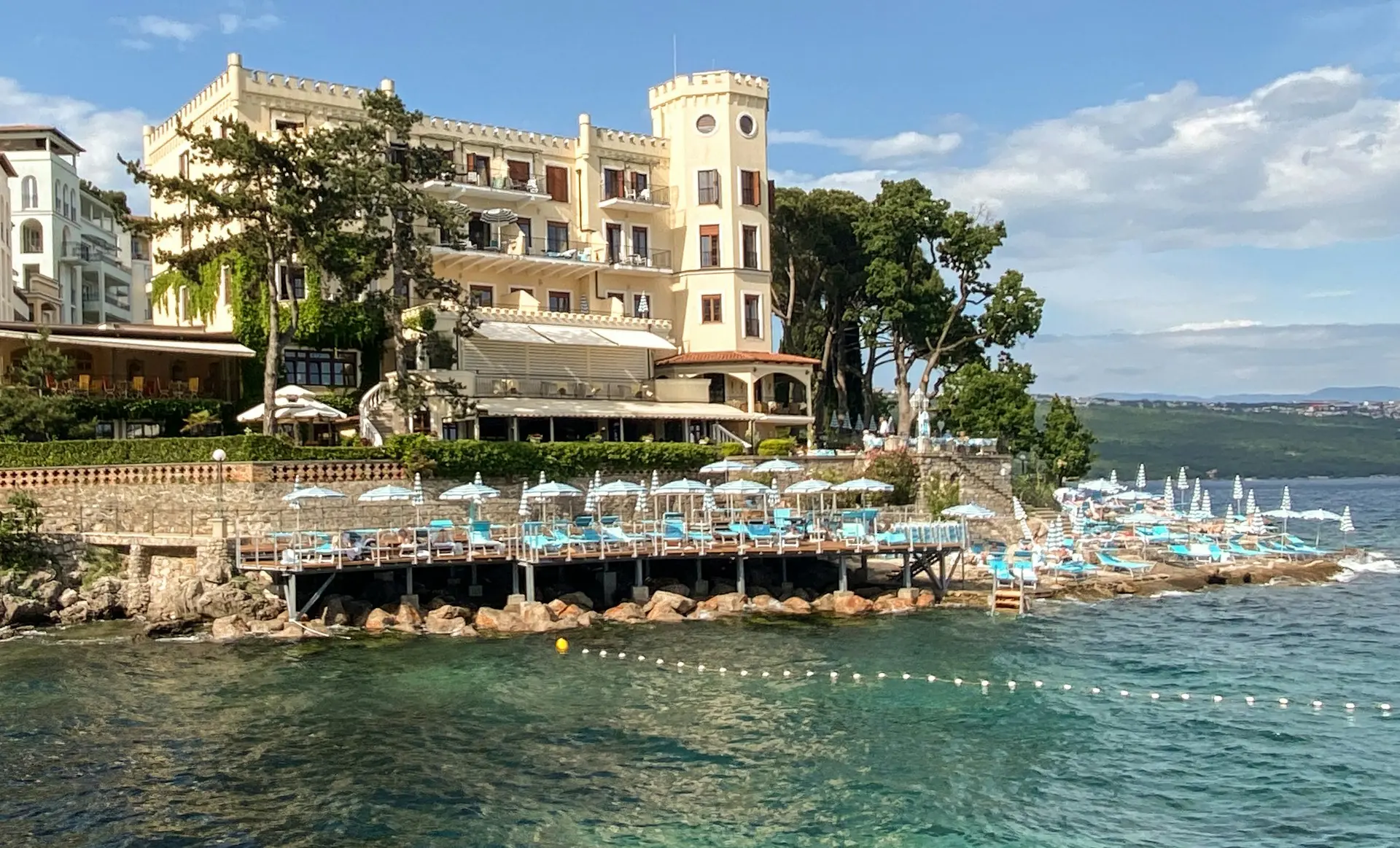 Seaside view of Opatija with elegant hotels, sun loungers, and the Adriatic Sea.